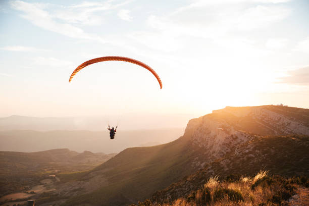 Parapente dans les montagnes au coucher de soleil